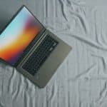 gray Asus laptop on white bed sheet