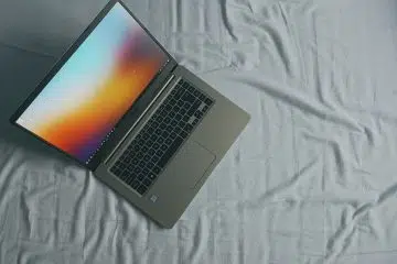 gray Asus laptop on white bed sheet