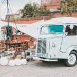 white and green volkswagen t-2 van parked beside brown brick building during daytime