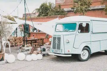 white and green volkswagen t-2 van parked beside brown brick building during daytime