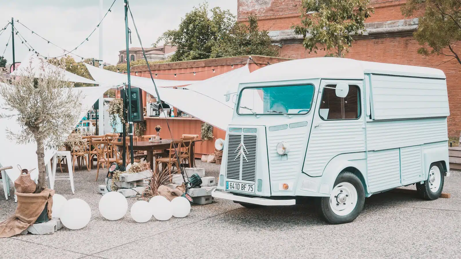 white and green volkswagen t-2 van parked beside brown brick building during daytime