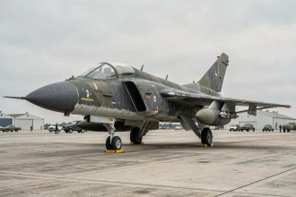 F-4 Phantom II exposé sur un tarmac de musée aéronautique, vue trois-quarts révélant le camouflage militaire usé et les détails de structure