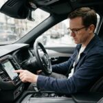 Homme dans la quarantaine au volant d'une voiture moderne