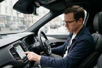 Homme dans la quarantaine au volant d'une voiture moderne