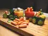 sliced carrots and green bell pepper on brown wooden chopping board